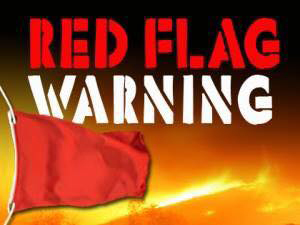 A red flag waves on the left with bold text above it reading "RED FLAG WARNING" against a fiery, orange and black background.