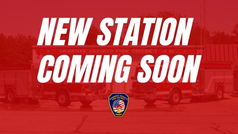 Bold white text reads "New Station Coming Soon" over a red background with a faint image of fire trucks and the Shawnee Heights Fire District badge at the bottom.